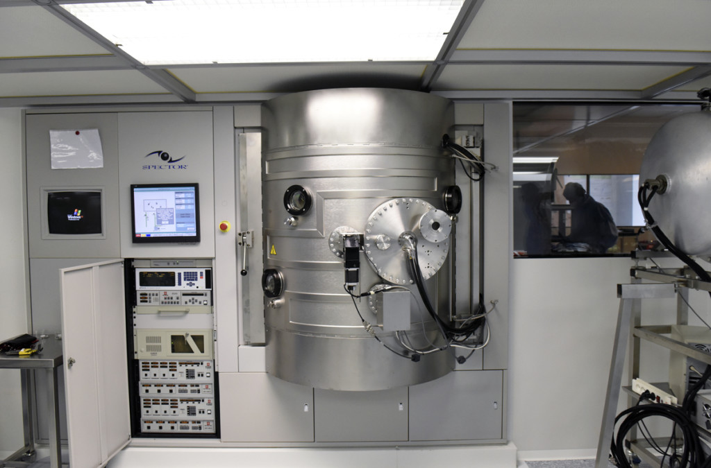 Vue d'une machine de dépôt commerciale par pulvérisation par faisceau d'ions. Cette machine peut traiter 6 pièces de 50 mm de diamètre en même temps