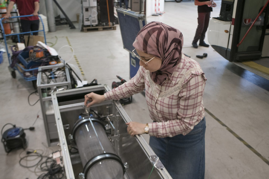 Amira Jabbari, post-doctorante à l’IRCELYON effectue les réglages sur l’appareil simulant la réaction chimique entre les gaz d’échappements et l’atmosphère, entraînant la production d’aérosols secondaires.